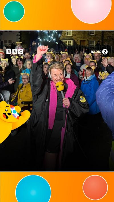 Sara Cox with her hand in the air