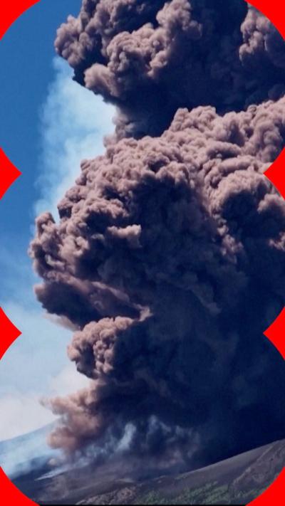 Huge plumes of earthy coloured smoke are seen billowing from the summit of Mount Etna, against a blue sky