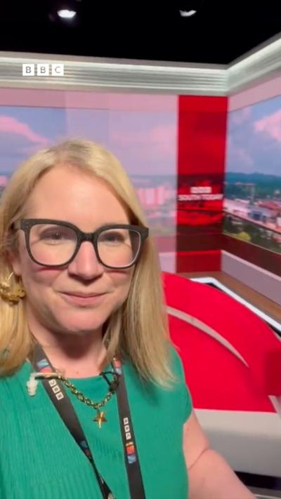 A woman with blonde hair wearing a green top