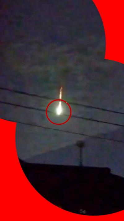 A meteor blazing through the sky over Mount Fuji is circled in red