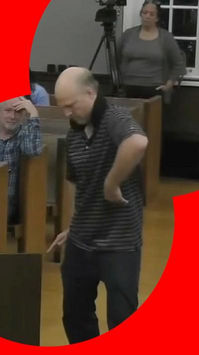 Man breakdancing in council meeting