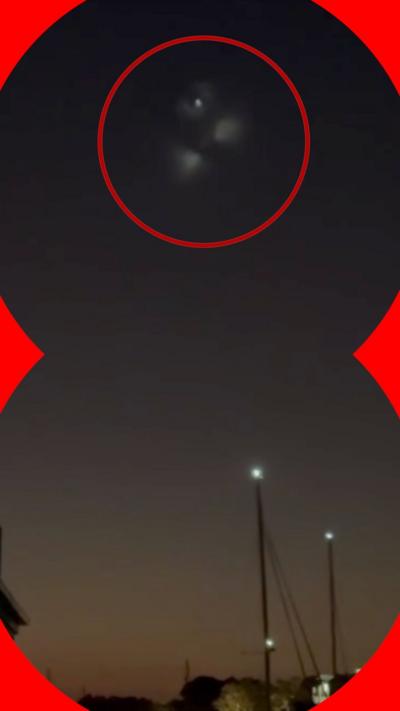 An image of three bright lights in the evening sky, with a red circle around it