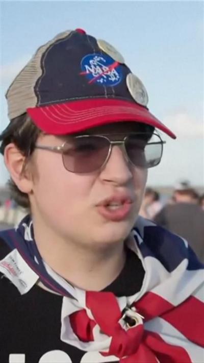 Woman wearing NASA hat and USA flag as a cape