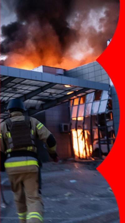 A fire fighter running towards a burning building in Kyiv
