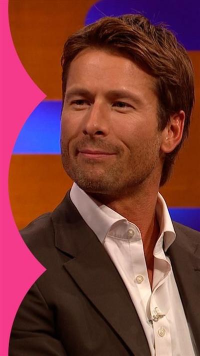 Glen Powell on the Graham Norton show wearing a brown suit and a white shirt