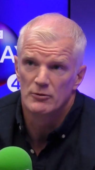 Al Carns speaking into a microphone