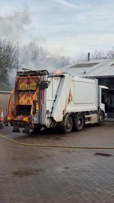 A white bin lorry on fire