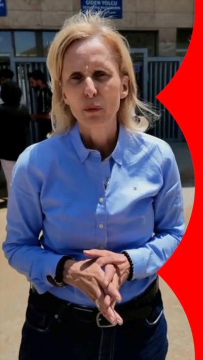 Orla Guerin stands with her hands together, she wears a blue shirt.