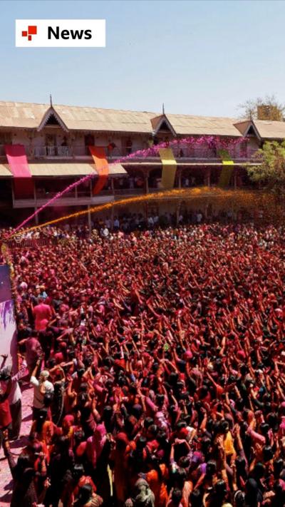 Revellers smeared with gulal (colour powder) celebrate Holi at a temple in Ahmedabad