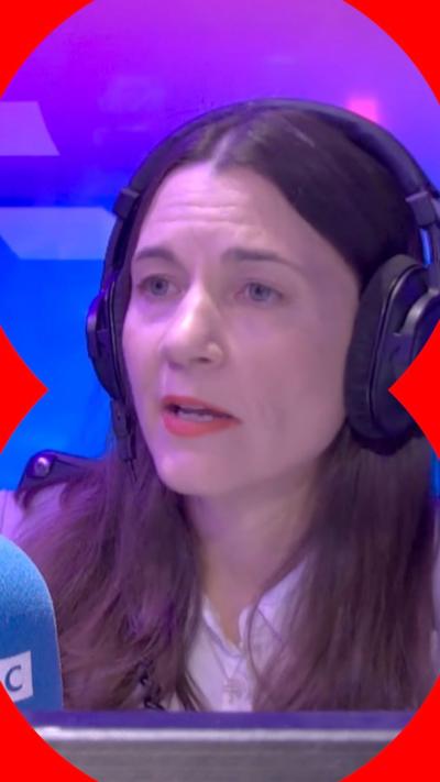 Lauren Schultz in a white top wearing black headphones in a radio booth