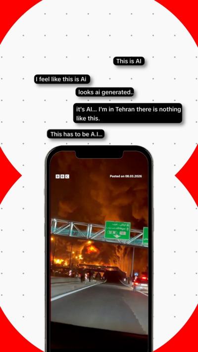Image of smartphone displaying oil depot fire in Iran. Graphics surrounding the phone display comments that read: This is AI.