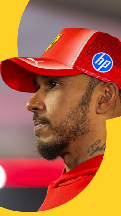 Lewis Hamilton looking into the distance wearing a Ferrari cap