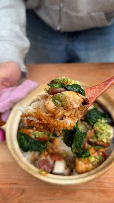 A spoon of chicken and mushroom claypot rice. 