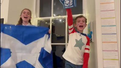 Kids celebrating with Scotland flag and foam finger 