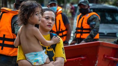 Woman with a child surrounded by emergency workers