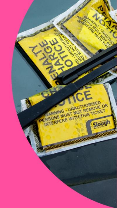 Multiple yellow parking tickets under a windscreen wiper.