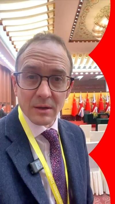 A man, Chris Mason, looks to camera in China's Great Hall of the People.