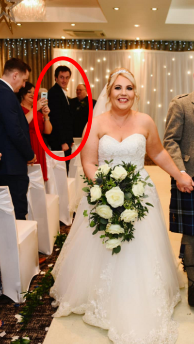 A bride in a white dress with blonde hair and white roses. Behind her is a man looking confused among rows of guests - he is highlighted with a red ellipse.