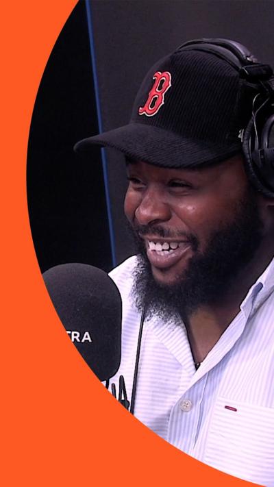 Actor Samson Kayo smiles across a 1Xtra sound desk