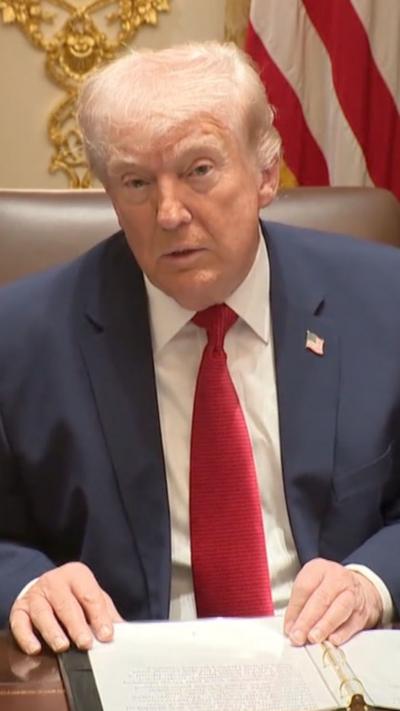 Trump sat in the Oval Office and looking into the camera