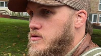 A man wearing a beige cap 