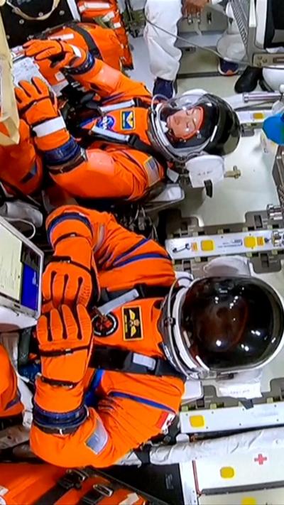 Crew inside capsule wearing their suits