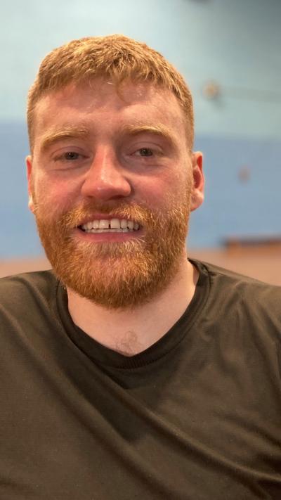 a man with red hair and a beard smiling at the camer