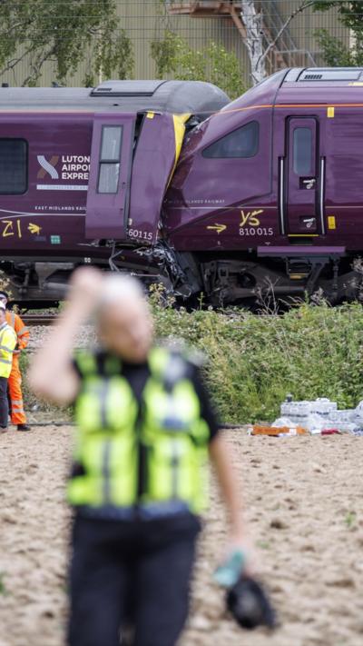 Scene of Bedford train crash with police offier in foreground