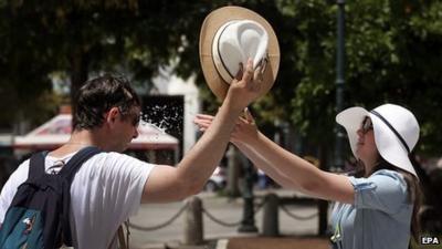 Man being cooled down with water and sunhat