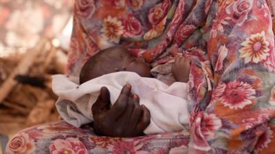 Baby Mohamed being held by his mother