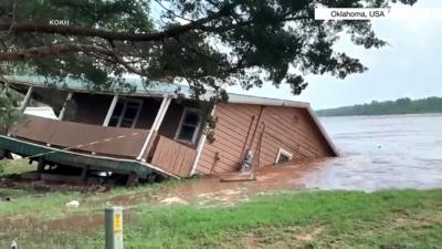 House slides into flooded river