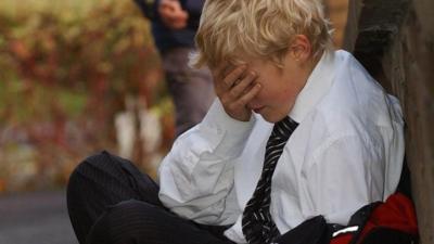 Posed photograph simulating a child being bullied bullying