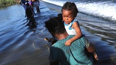 A child is carried over the Rio Grande on the US-Mexico border, 17 September 2021