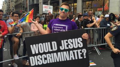 A protestor with a signing saying "Would Jesus discriminate?"