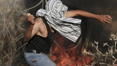 Palestinian throwing stone during Gaza clashes