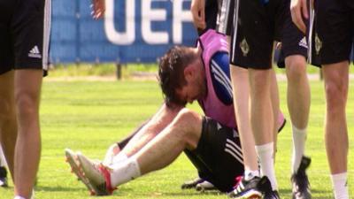 Kyle Lafferty looks in pain during Northern Ireland's training session in France