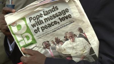 Man holds a local newspaper in Nairobi