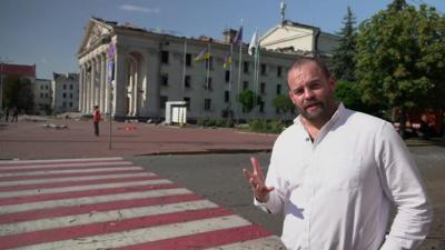 James Waterhouse in front of damaged theatre building in Chernihiv