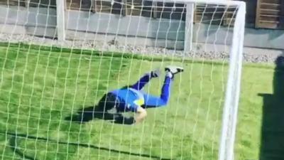 A child diving in goal