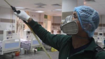 Man spraying disinfectant in hospital