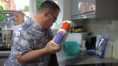 Adam making breakfast with the help of a computer tablet