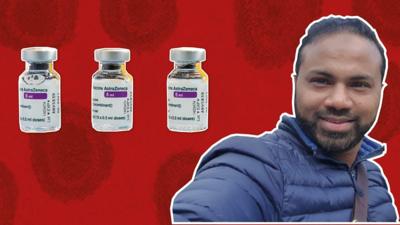 Dr Abdul Mannan in front of a red background with vials of Astrazeneca vaccine in the foreground