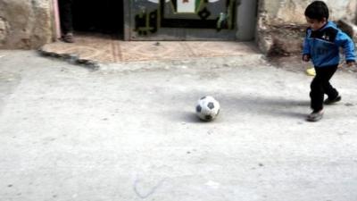 Boy playing football in Damascus