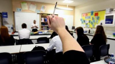 Student with raised hand in class