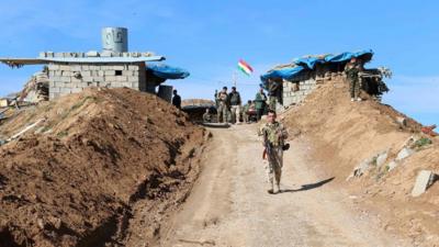 Kurdish peshmerga forces monitoring trenches they dug