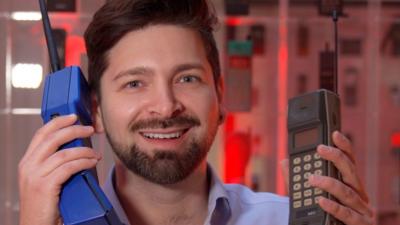 Chris Fox holding two huge retro mobile phones