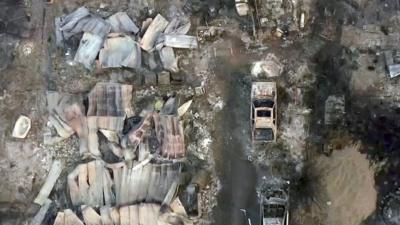 Aerial shot of burned-out building and cars