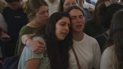 Mourners at prayer hall at a cemetery in Kfar Etzion