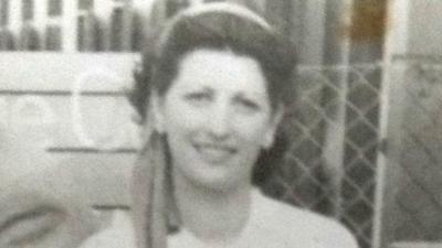 A black and white photo of a woman in a head scarf