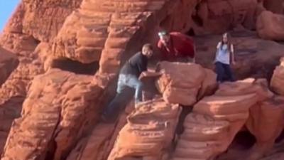 Two people push a rock in Lake Mead, Nevada